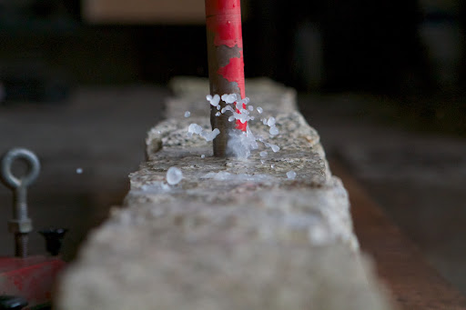 Water is used in the drilling process to keep the drill bit cool. Drilling through such dense stone takes time.