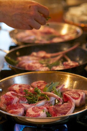 Working with three hot skillets, Pierre seared the lamb on both sides over a very hot flame.