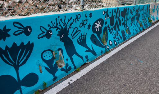 To visually improve the construction site, a volunteer program was organized to paint the cement construction barriers.