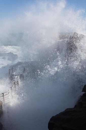 The same wave - At the end of this inlet, down low, is a small cavern where, when the rush of the wave arrives, air and water is forced out like a clap of distant thunder.
