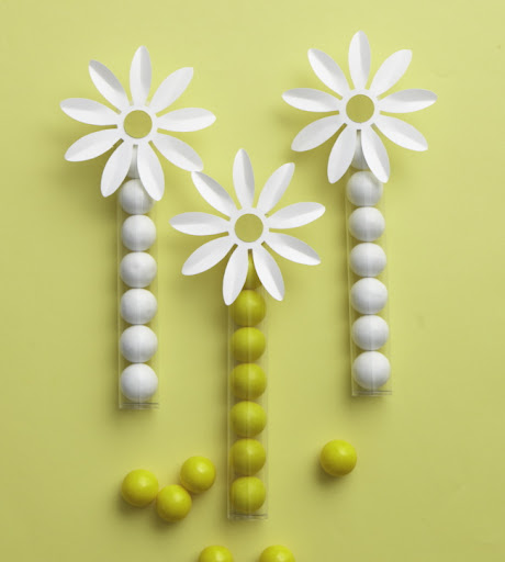 Candy bought in bulk can be used for favors, like these plastic tubes with flower toppers.