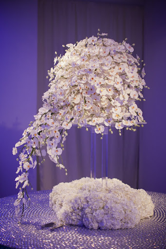 Sylvia Weinstock, cake designer to the stars, created an amazing white wedding cake with a curtain of sugar orchids draped over the tiers. Photo credit: Mel Barlow