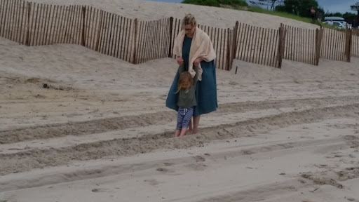 Jude loves being dragged, suspended and carried on shoulders. Here she is making sand waves with Alexis.