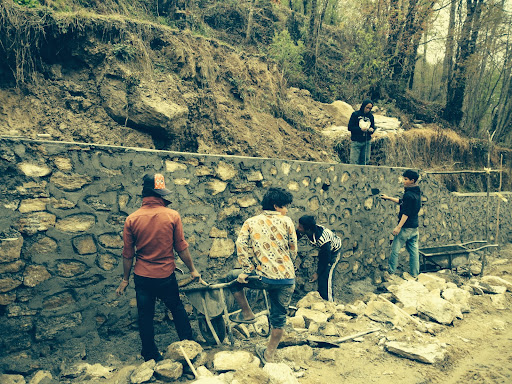 Happily, the government recently approved a road construction. Here you see hired hands building a barrier wall for the road.