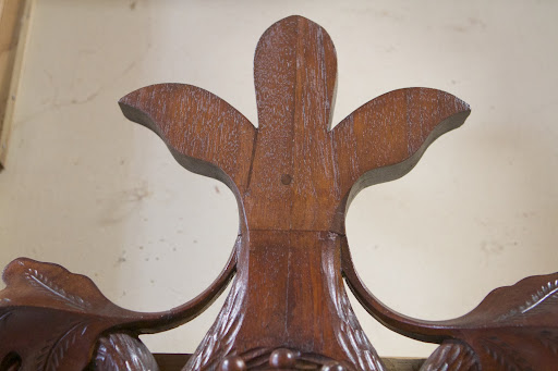 At some point in its history, the top of the stand was cut off, probably to fit a space. This fleur-de-lis was made and added.