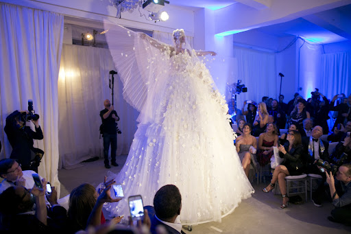 Reem Acra, created a 15-foot gown out of 400 yards of tulle and 1,000 flowers. It glided down the aisle, the tulle opened up, and Preston emerged. It was quite an entrance! Photo credit: Mel Barlow