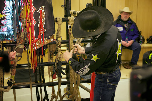 Next, we talked about the bull rope, which is wrapped around the bull's chest directly behind his front legs. The flat rope has a leather handle braided into it that the cowboy grips. The tail of the rope then passes through the palm, behind the hand, and back through the palm.