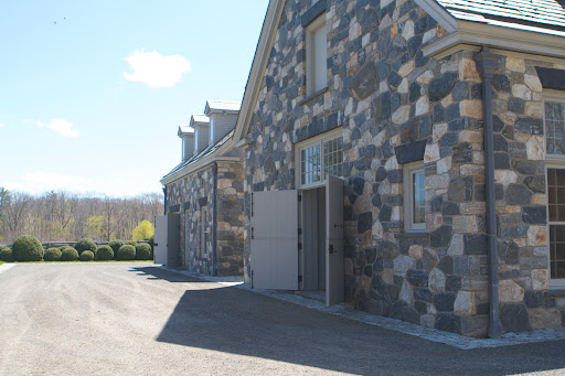 The structure is made from local stone with the exception of the dark keystones above the doors and window. That is black Chinese granite. All the windows are wavy restoration glass and the roof is durable slate.