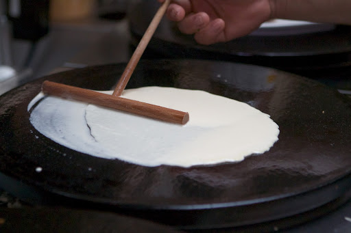 A special crêpe stick is used to spread the batter.