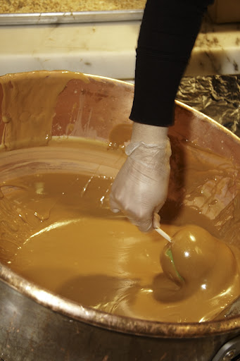 Chocolatier Amanda Greenwood dips an apple.