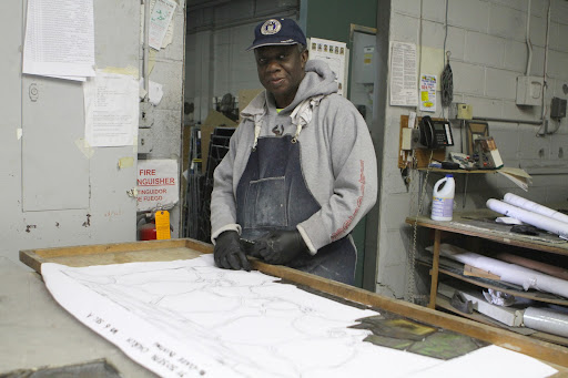 After cleaning the glass, Vincent places the pieces on the cartoon to begin the reassembly process.
