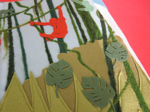 There are many layers and techniques on each page. In the jungle, wool felt, wool roving, and felted wool fabric were applied to the cashmere background.