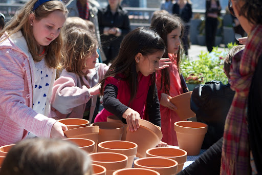 Isabel Tavarez, daughter of Maintenance Associate Pete Tavarez, chooses a terra cotta pot to do her planting