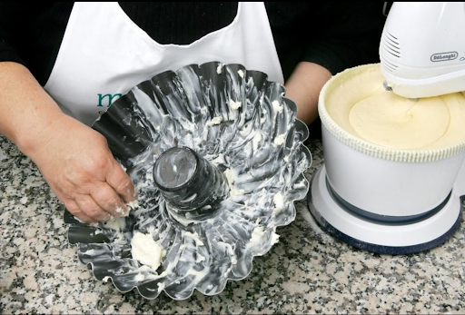 Generously buttering the fluted cake pan allows for easy removal later. Softened butter works best. Using your fingers or a pastry brush will help you get into every nook and cranny.