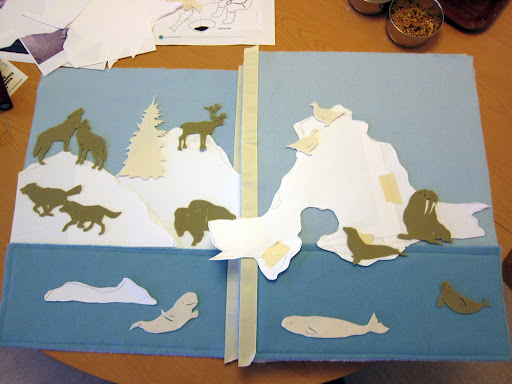 Once I designed all the animal silhouettes, I arranged them on a blank page to think about the composition and how I wanted to design the background. I cut the iceberg shapes out of paper first, before jumping into needle felting.