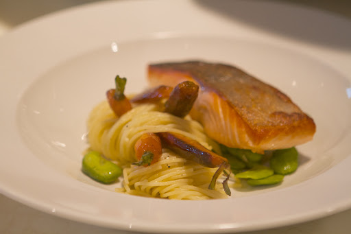 The salmon was laid on the plate and freshly picked roasted baby carrots were tucked into the spaghettini.