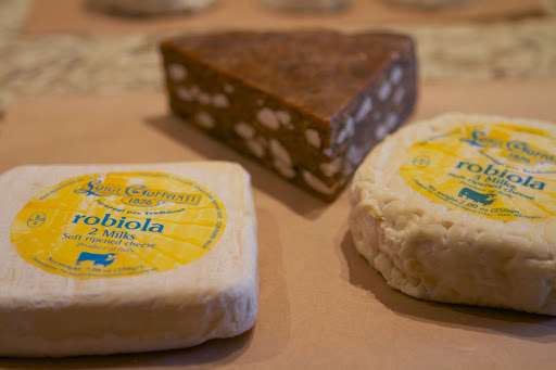 Of course, there are cheeses from famous cheesemaking regions of Europe. Robiola is a wonderful soft-ripened cheese from Italy, made with varying proportions of cow’s, goat’s milk, and sheep milk. Behind the Robiola is a fig and almond cake, which is great with cheese.