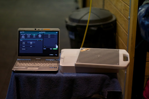 To the right is the portable x-ray machine equipped with a radio transmitter to beam the x-ray images to the laptop on the left.