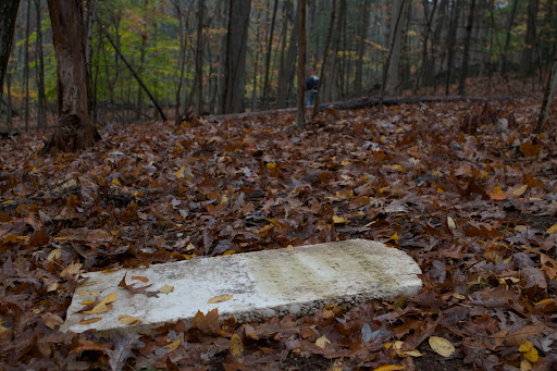 Someone found the stone in the woods, away from the main part of the cemetery and carried it there to be near the other graves. However, a volunteer of the group poked around in the woods and found that the deceased was, indeed, buried apart from the others!
