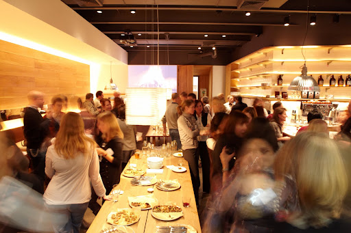 The dining room at Co. is minimalist with clean lines and warm wood. It's a very welcoming room that seats 54. There are 2 long communal dining tables in the middle and individual tables on the side.