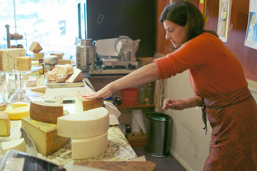 Audrey at work with her cheese cutter - This countertop cutter is fashioned with a wire for cutting wedges of cheese accurately and quickly. This tool can be used on all types of cheese.