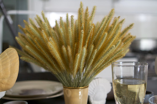 The centerpieces are full but unfussy - bunches of Timothy grass, wheat, and foxtail gathered in gold lusterware cups.