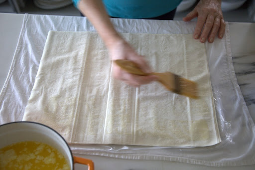 I started the assembly by brushing a sheet of good-quality Greek phyllo dough with the clarified butter.