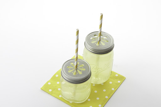 If you are like me, you have many mason jars around the house for preserving and canning. Modified lids act as decoration as well as a straw holder.