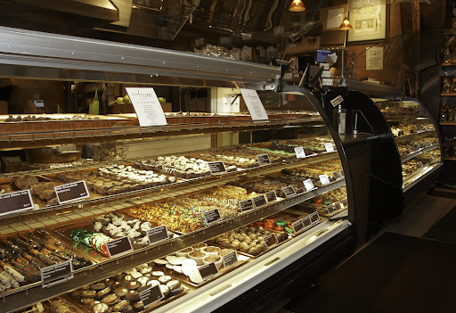 There is an assortment of chocolates for sale, including truffles, almond bark, and toffee.