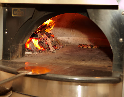 The oven at Co. is a gas-fired Earthstone oven. Flavorful hard wood is also burned to aromatize the pies.