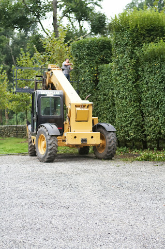 The cage palette of the Hi-Lo provides much more stability when reaching than a ladder does. And because this is a parking area, the Hi-Lo can be used here.