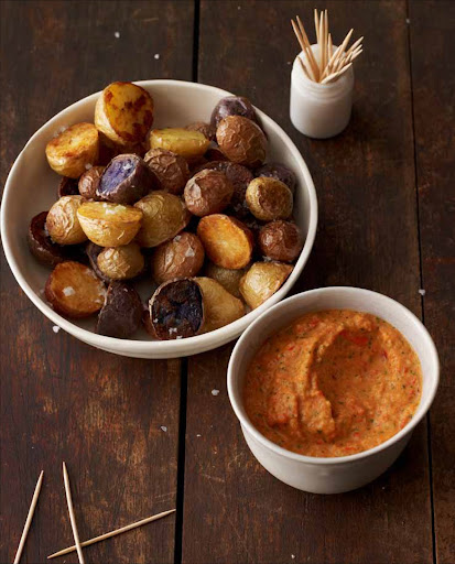 Roasted Potatoes with Romesco Sauce - Romesco, from the Catalonia region of Spain, is a versatile all-purpose sauce. Versions about, some made with fresh tomatoes, others, like this one, with red peppers. All are thickened with nuts and sometimes bread. Romesco is delicious with roasted potatoes.