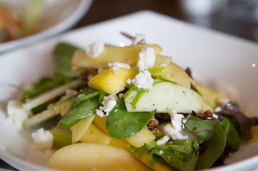 This is a Mangolicious Salad made with mango, apple, tomato, pecans, local greens, and feta cheese.