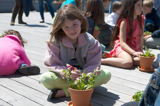 Catherine, niece of SVP, Finance – Merchandising Ann Henry smiles after finishing planting her petunias