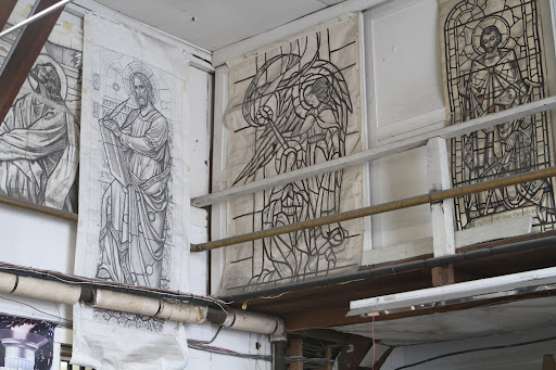 These are called cartoons and there are many hanging on the walls from previous jobs. The cartoons are made by laying a sheet of paper over the window before taking it apart and rubbing with a special pencil.