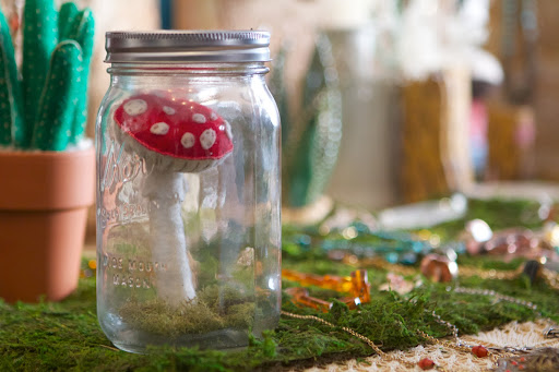 A felt Amanita Mushroom in a Mason jar terrarium