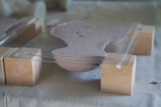 The mold is set on blocks to stabilize and the mix poured in to fill the mold. A gentle tapping of the mold removes air bubbles and also settles and levels the mixture.