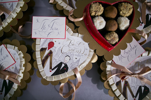 Preston asked Darcy to make the favors for the wedding. She chose heart-shaped Jacques Torres truffle boxes and sketched the couple standing before the NYC skyline. Photo credit: Mel Barlow