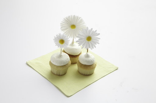 You don't have to be a professional baker to have well-decorated cupcakes. Here, flower stickers affixed to toothpicks dress up a large dollop of frosting.