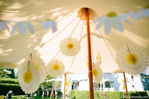 Here, the paper daisy flowers hang from the inside of the tent.