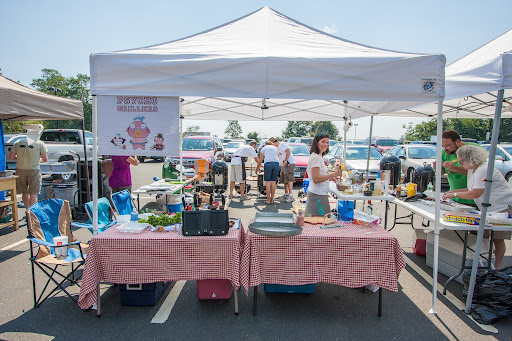 The team was hard at work as Lynn spied on the neighbors to see what they were making. On the front table, they displayed their awards from prior years, including their Grand Champion trophy. The team logo sits in the upper left corner of the tent.