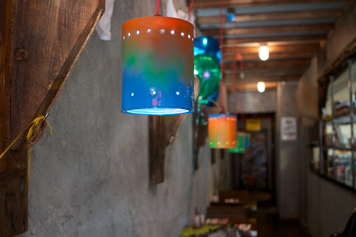 She purchased paint cans from The Home Depot, punched holes around the sides, painted them colorfully, and wired them as hanging fixtures.