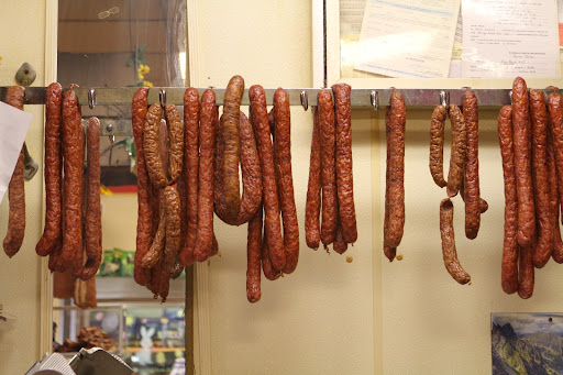 House-made kielbasa in various tastes and sizes hangs, ready to be sold. The entire process of grinding and seasoning the meat, stuffing the sausages, and smoking them, takes place right in the store.