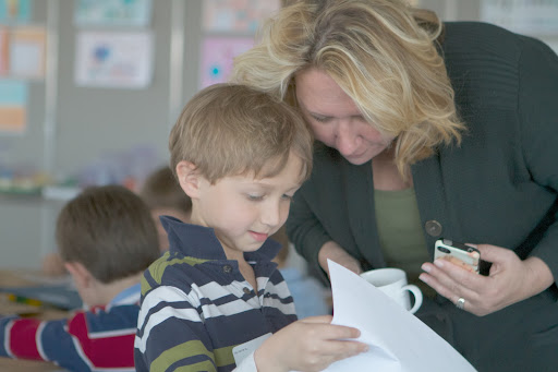 SVP, Video Development and Programming Kimberly Miller Olko looks over son Austin's project,